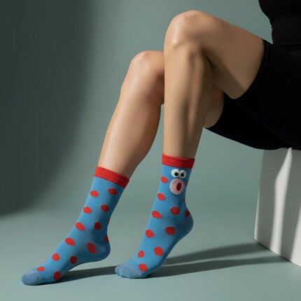Blue playful polka-dot socks with red dots and a cartoon face design on model’s legs by EmotiForce Australia